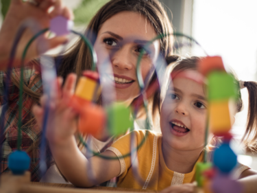 Young female EA playing a game with young female child