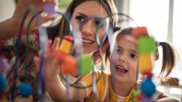 Young female EA playing a game with young female child